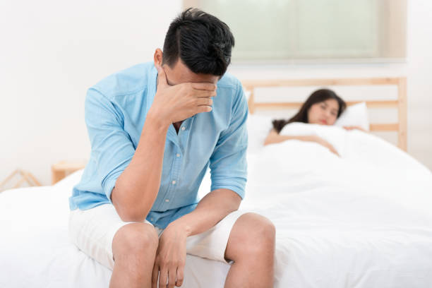 Husband unhappy and disappointed in the erectile dysfunction during sex while his wife sleeping on the bed. Sexual Problems in Men. Husband unhappy and disappointed in the erectile dysfunction during sex while his wife sleeping on the bed. Sexual Problems in Men. low photos stock pictures, royalty-free photos & images