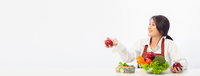 Asian young woman is happy holding fresh fruit apple with vegetables,  Healthy, Fresh food, Clean eating recipes to fuel body from the inside out concept with copy space banner.