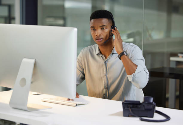 istock Shot of a young man using a headset and computer in a modern office 1333685021