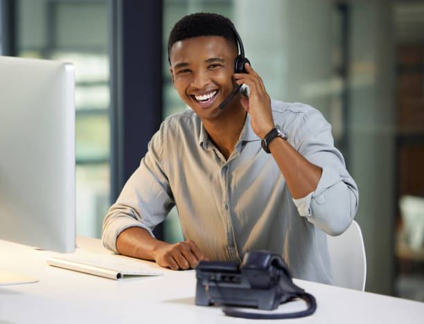 istock Shot of a young man using a headset and computer in a modern office 1333685158