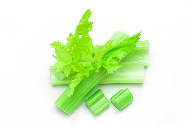 istock Fresh Chopped Celery Sticks and Slices with Leaves and Water Drops Isolated on White Background 1333686069