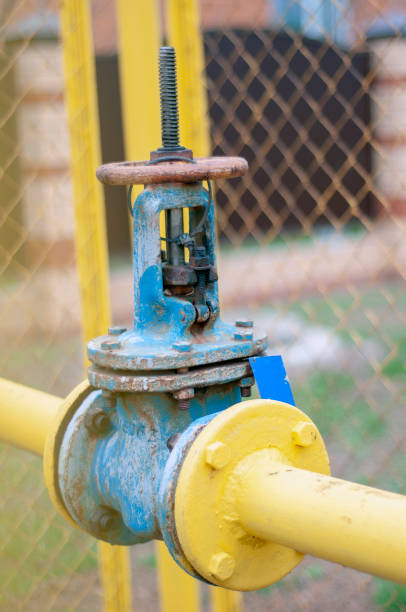 istock Natural gas gate valve, painted blue with yellow pipes attached, close-up 1333687632