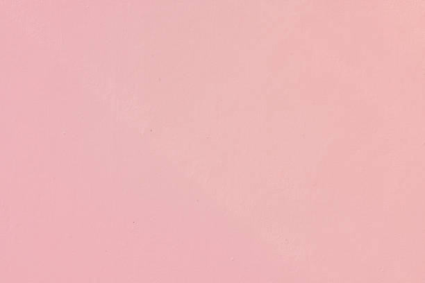 Part of an old concrete wall painted pink.