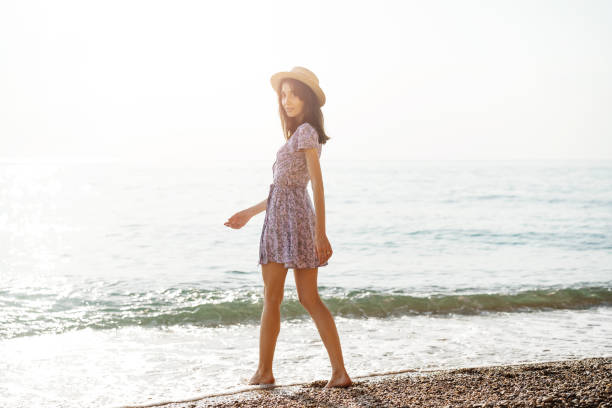 istock Lonely young woman walks on the seashore at sunset 1333689371