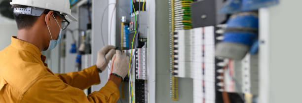 Electrician engineer using digital multimeter test current electric in control panel "u200bfor testing electrical installations and wiring work in power control room on new building. stock photo