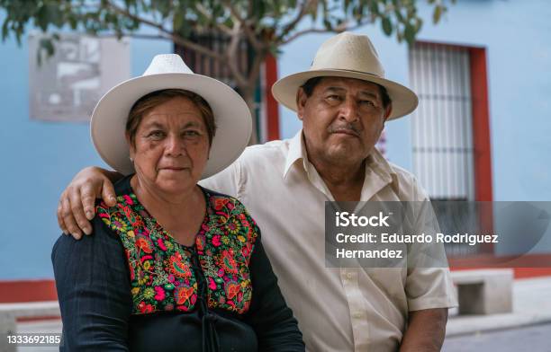 Latin Couple Of Grandparents Sitting Outdoors In Colorful Streets Of Oaxaca Mexico Stock Photo - Download Image Now