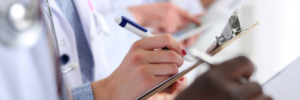 istock Group of doctors hold pens and clipboard pads 1333692226