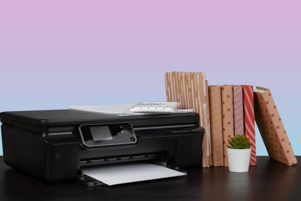 istock Home laser printer on desk against purple background 1333693013