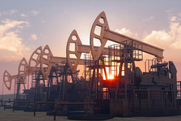 Oil Well With Drilling Rigs And Pumpjacks On Sunset
