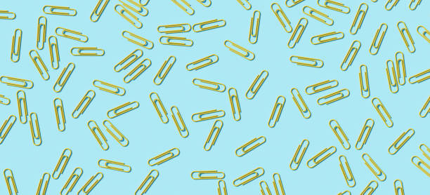 istock Yellow paper clip on blue background, 3d render Stock Picture 1333694088