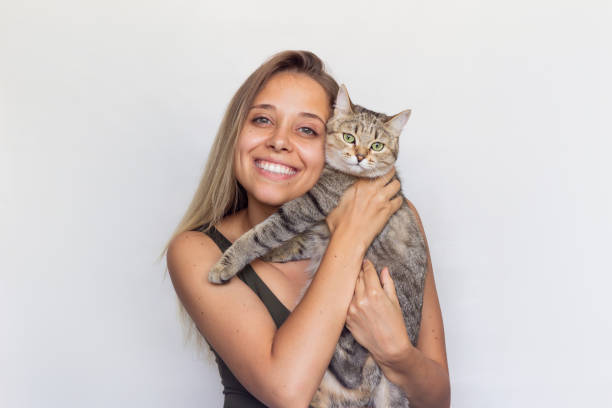 uma jovem loira segura o gato tabby. - pets embracing one person portrait - fotografias e filmes do acervo