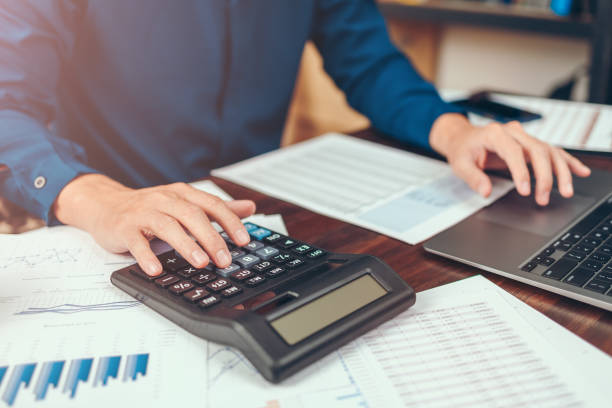 istock accountant working and analyzing financial reports and use calculator on office desk. finance and business concept. 1333696475