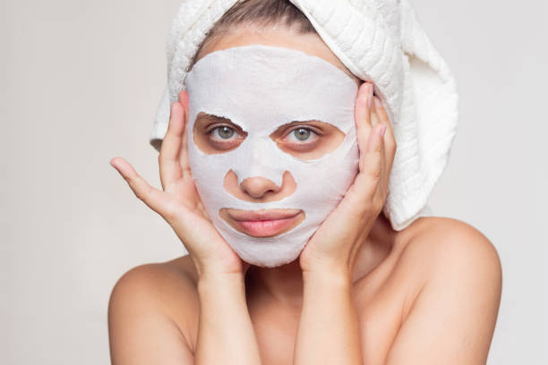 istock A young woman puts a fabric cosmetic moisturizing mask on her face 1333696567