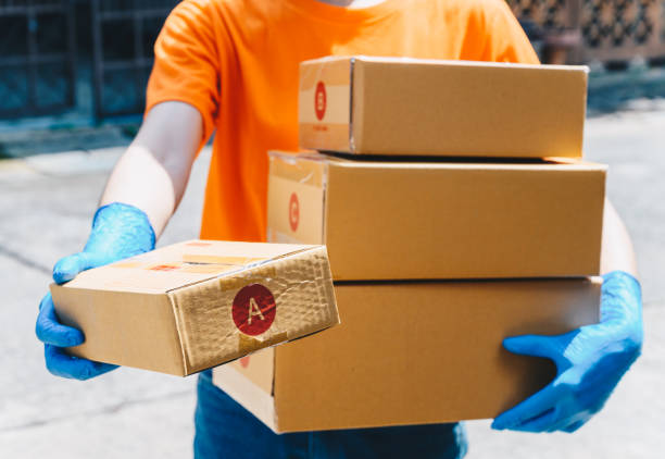istock Delivery service courier sending boxes mail to customer while wearing glove for protect herself in covid-19 pandemic outbreak. 1333704209
