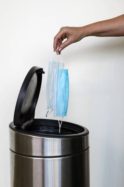 istock A woman's hand throwing out medical face masks in a rubbish bin 1333704598