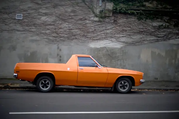 Photographed is a vintage orange Holden ute parked in the bayside suburb of Elwood, Melbourne. Australia.