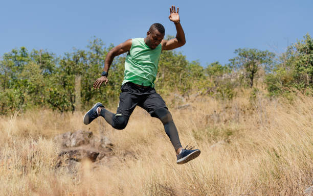 African american man athlete runner exercise training and jumping  outdoors in beautiful mountain nature landscape. Active health and motivation lifestyle and Adventure Concept