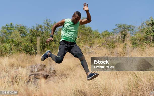 African american man athlete runner exercise training and jumping  outdoors in beautiful mountain nature landscape. Active health and motivation lifestyle and Adventure Concept