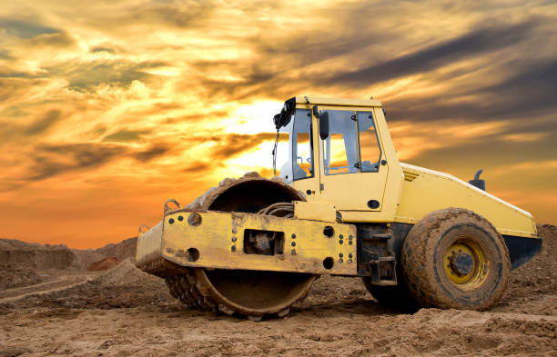 istock Soil Compactor for leveling ground for the foundation and on road construction. Road compaction equipment at construction site. Vibration single-cylinder road roller on amazing sunset background. 1333711815