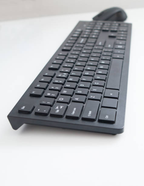 istock Black keyboard and the mouse on a white table, isolated, close up 1333713261