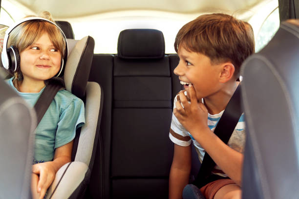 frères et sœurs heureux sur le siège arrière de la voiture - seat belt audio photos et images de collection