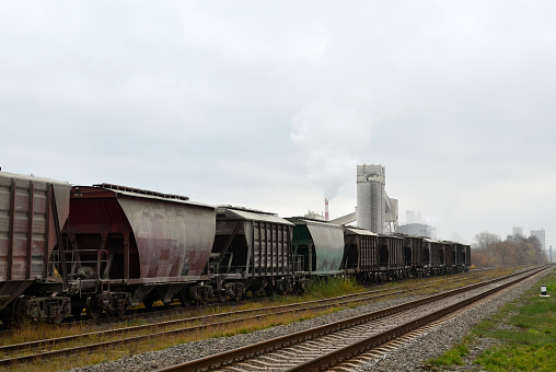 Railroad cars at cement manufacturing plant. Ready-mix and building materials. End products being shipped by rail from the concrete factory. Freight cars, hopper car for sand or mineral products