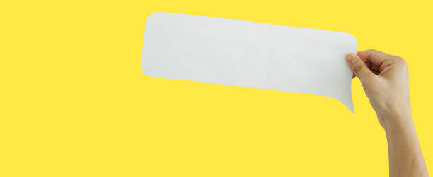 istock close up man hand hold speech bubble paper cut isolated n yellow background for design concept 1333720334