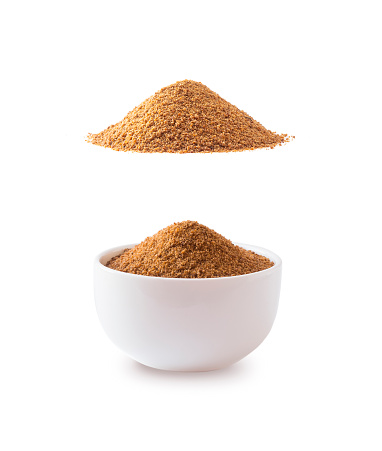 Heap of coconut sugar isolated on white background. Heap of coconut sugar on white. Dark sugar isolated on white. Organic coconut unrefined sugar, isolated. Selective focus. Top view.