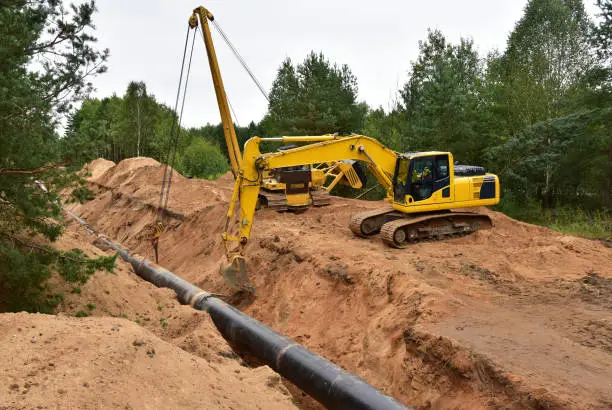 Photo of Natural Gas Pipeline Construction. Laying oil pipe in a trench in the ground. Petrochemical industry concept. Refining crude oil