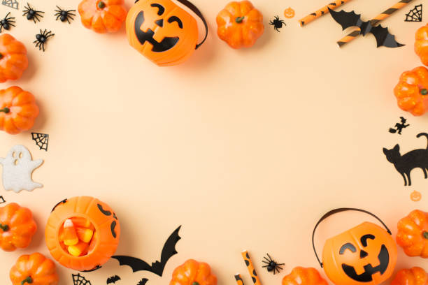 vista superior foto de halloween decoraciones cestas de calabaza pajas de maíz caramelo pajas araña tela murciélagos fantasma y siluetas de gato negro sobre fondo beige aislado con copyspace en el medio - halloween fotografías e imágenes de stock