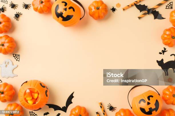 Top View Photo Of Halloween Decorations Pumpkin Baskets Candy Corn Straws Spiders Web Bats Ghost And Black Cat Silhouettes On Isolated Beige Background With Copyspace In The Middle Stock Photo - Download Image Now