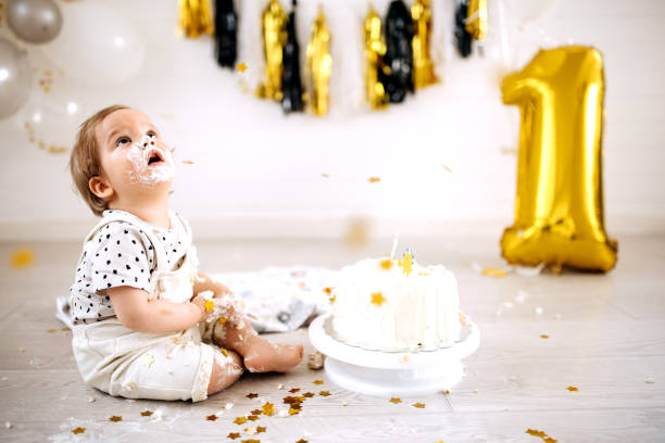 istock Cute messy little boy with cake on his first birthday party 1333725361