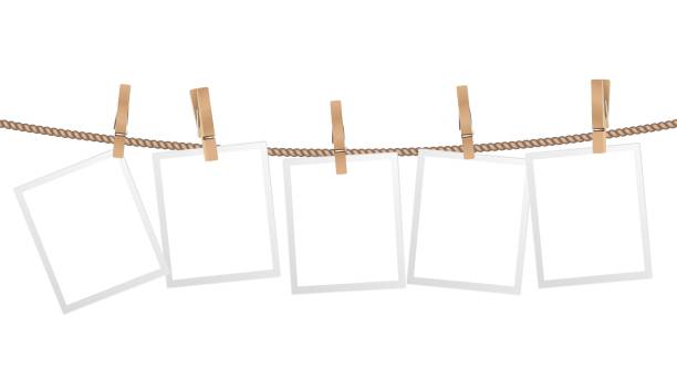 Realistic photo frames. Frame hanging on wooden clothespins on rope. Modern stylish decorative element for interior design, isolated scandinavian home accessory vector template Realistic photo frames. Frame hanging on wooden clothespins on rope. Modern stylish for interior design, isolated scandinavian home accessory vector template. Illustration blank empty photo picture clothespin wood stock illustrations