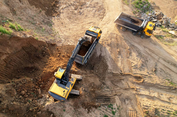 koparka ładuje piasek do wywrotki. widok z lotu ptaka koparko-ładowarki na roboty ziemne. - earth mover digging land bulldozer zdjęcia i obrazy z banku zdjęć