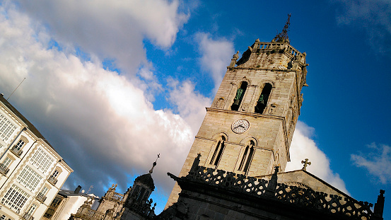Cathedral in Lugo city , bell and clock tower, galerías in Santa Maria town square, vertical view, Galicia, Spain.