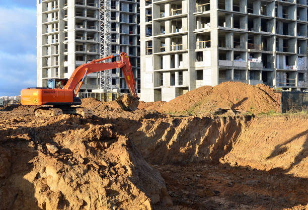 Excavator digging foundation at construction site. Heavy machinery for groungwork. House Construction Project Working. Excavator digging foundation at construction site. Heavy machinery for groungwork. House Construction Project Working. earthwork stock pictures, royalty-free photos & images