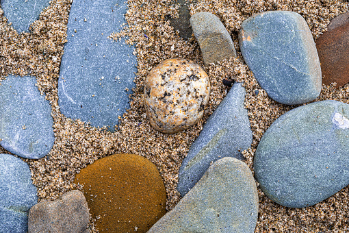 Close up of stones washed smooth by the sea on the coastline in Scotland on a summer morning