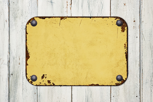 Vintage yellow tin sign on a wooden background
