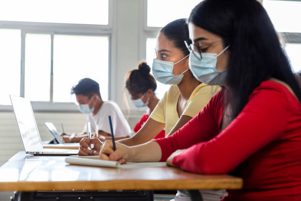 multiracial group of teen high school students studying in class wearing protective face mask. copy space. - multi ethnic group concentration student asian ethnicity imagens e fotografias de stock