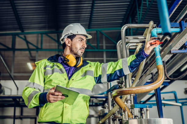 giovane ingegnere latino ispanico che lavora in una fabbrica industriale pesante. controllo del lavoratore tubo dell'acqua del gas oleoso nell'impianto. - condition foto e immagini stock