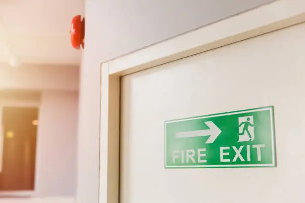 Photo of Emergency Fire exit door with alarm bell in condominium and commercial building.