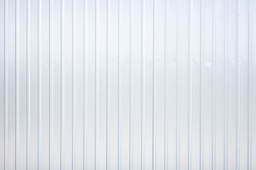 Striped wave silver steel metal sheet industry or construction site wall texture pattern for background.