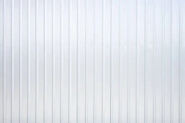 Striped wave silver steel metal sheet industry or construction site wall texture pattern for background.