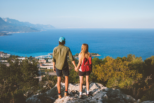 Couple in love man and woman holding hands on mountain top friends traveling together in Turkey enjoying view vacation trip lifestyle outdoor mediterranean sea landscape