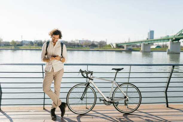 istock Cheerful young manager text messaging leaned on the bridge fence 1333736037