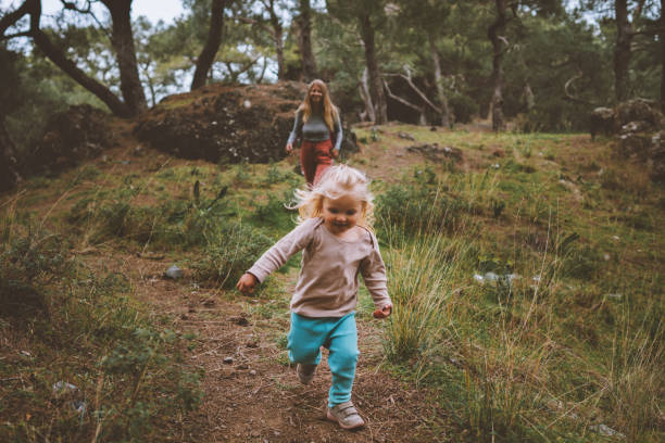 kind mädchen läuft im wald familienurlaub reisen lebensstil 2 jahre altes baby wandern mit mutter outdoor glückliche emotionen - family walking child toddler stock-fotos und bilder