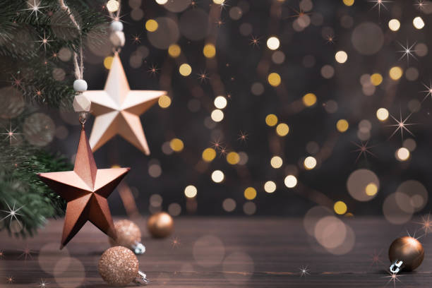 istock Festive composition with brown stars on fir tree on background garland lights. 1333739994