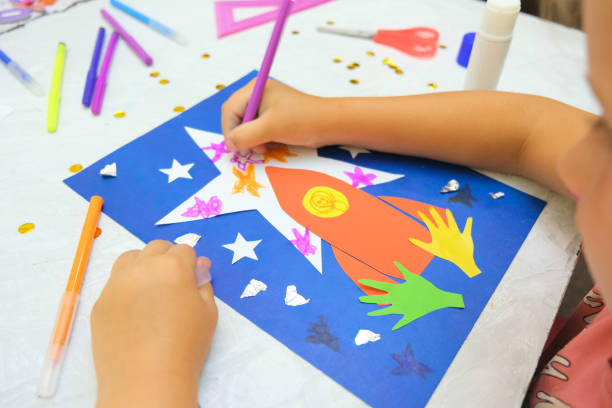 istock Child making rocket and stars from paper. Creative children play with craft. 1333740876