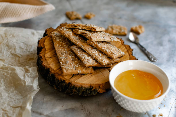 istock Crispy rectangular crispbreads with sesame seeds and seeds with natural honey in an interestingly decorated composition with wood and metal materials 1333742649