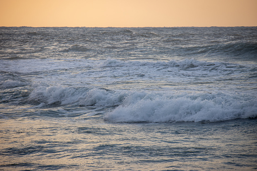 An incoming wave on the Black Sea and a pebble beach on the Sochi coast on a summer day with clouds, Sochi, Krasnodar Territory, Russia